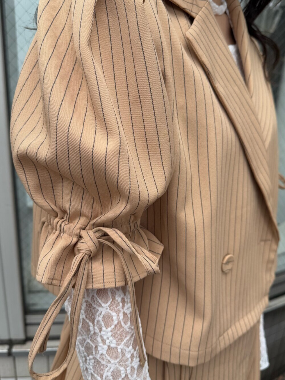 ブラック系のブーツ、ホワイト系のTシャツ/カットソー、ベージュ系のテーラードジャケットを着用したレディースの冬コーディネートの7枚目の写真