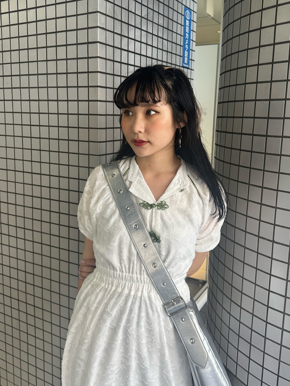 シルバー系のショルダーバッグ、ホワイト系のワンピースを着用したレディースの夏コーディネートの4枚目の写真