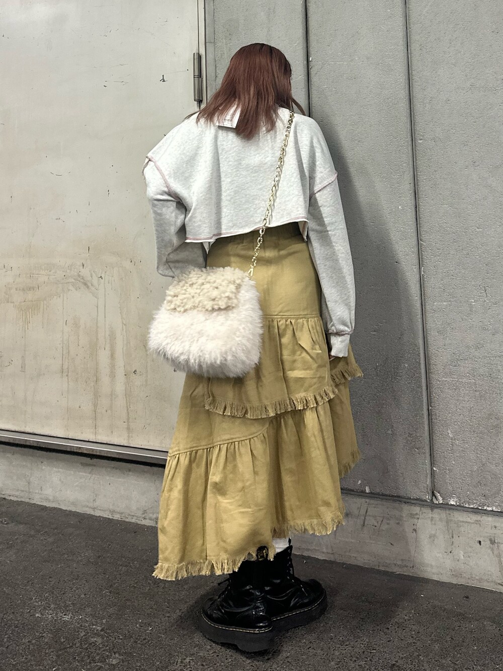 グレー系のスウェット、ホワイト系のハンドバッグ、ベージュ系のスカートを着用したレディースの冬コーディネートの3枚目の写真