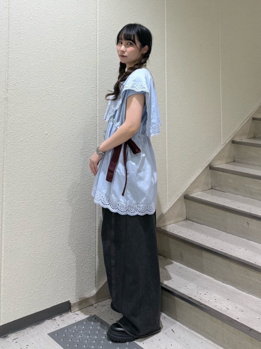 ブラック系のブーツ、ブラック系のデニムパンツ、ホワイト系のタンクトップを着用したレディースの夏コーディネートの2枚目の写真