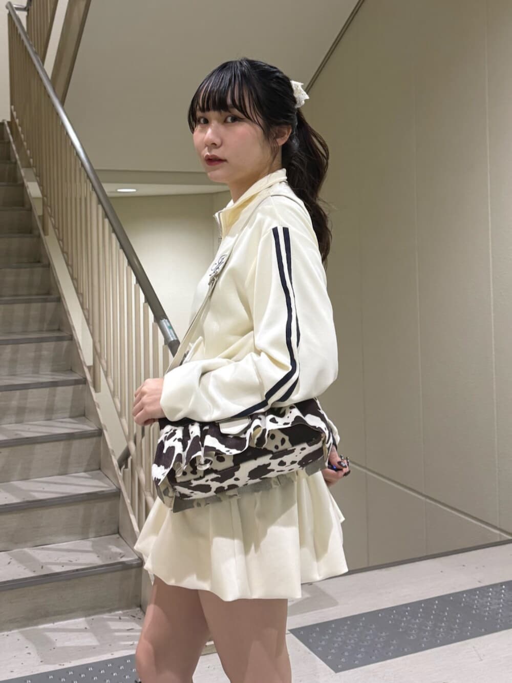 ブラック系のブーツ、ホワイト系のジャージ、ホワイト系のスカートを着用したレディースの冬コーディネートの8枚目の写真