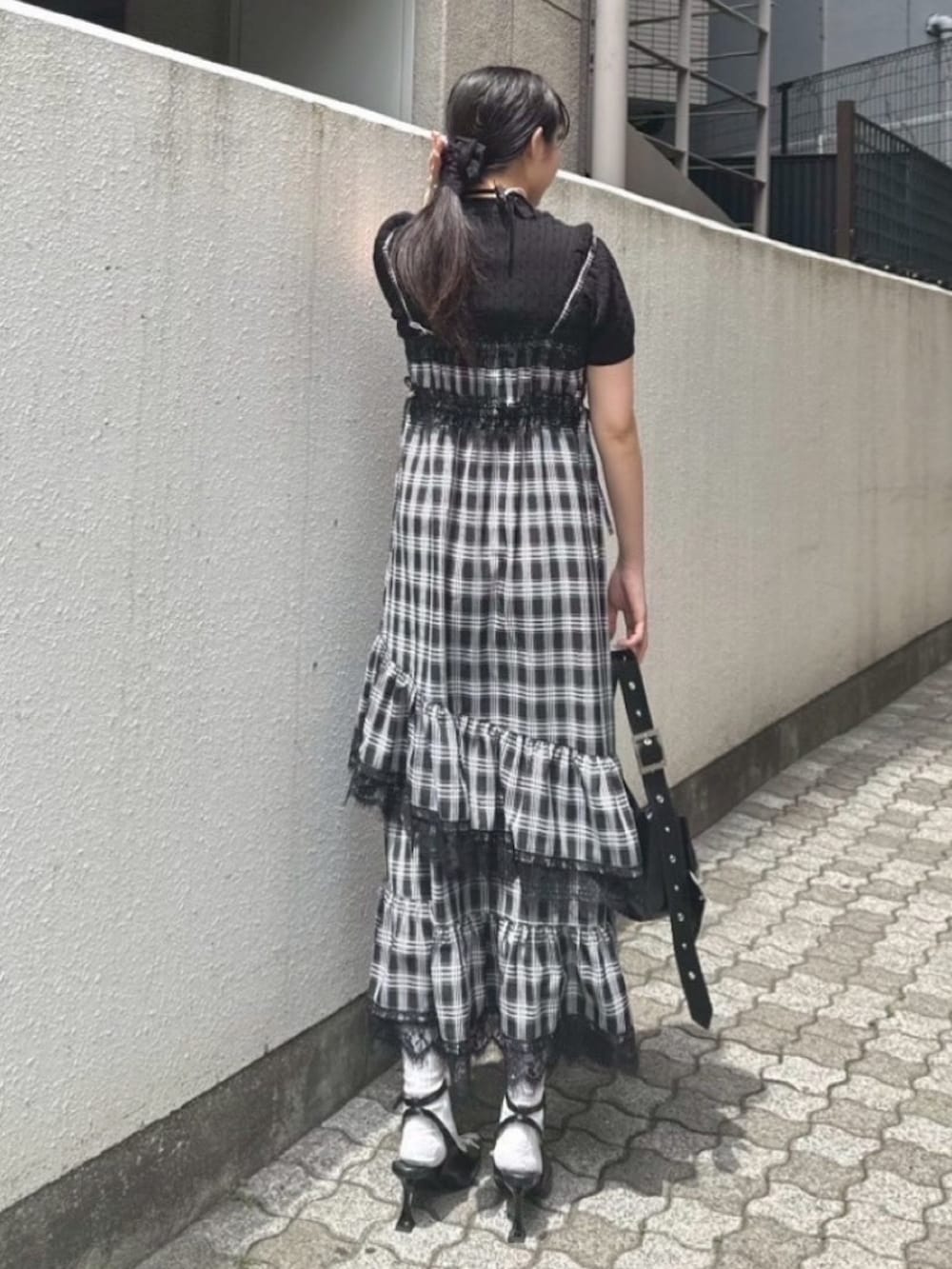 ブラック系のワンピース、ブラック系のニット/セーター、ブラック系のパンプスを着用したレディースの夏コーディネートの3枚目の写真