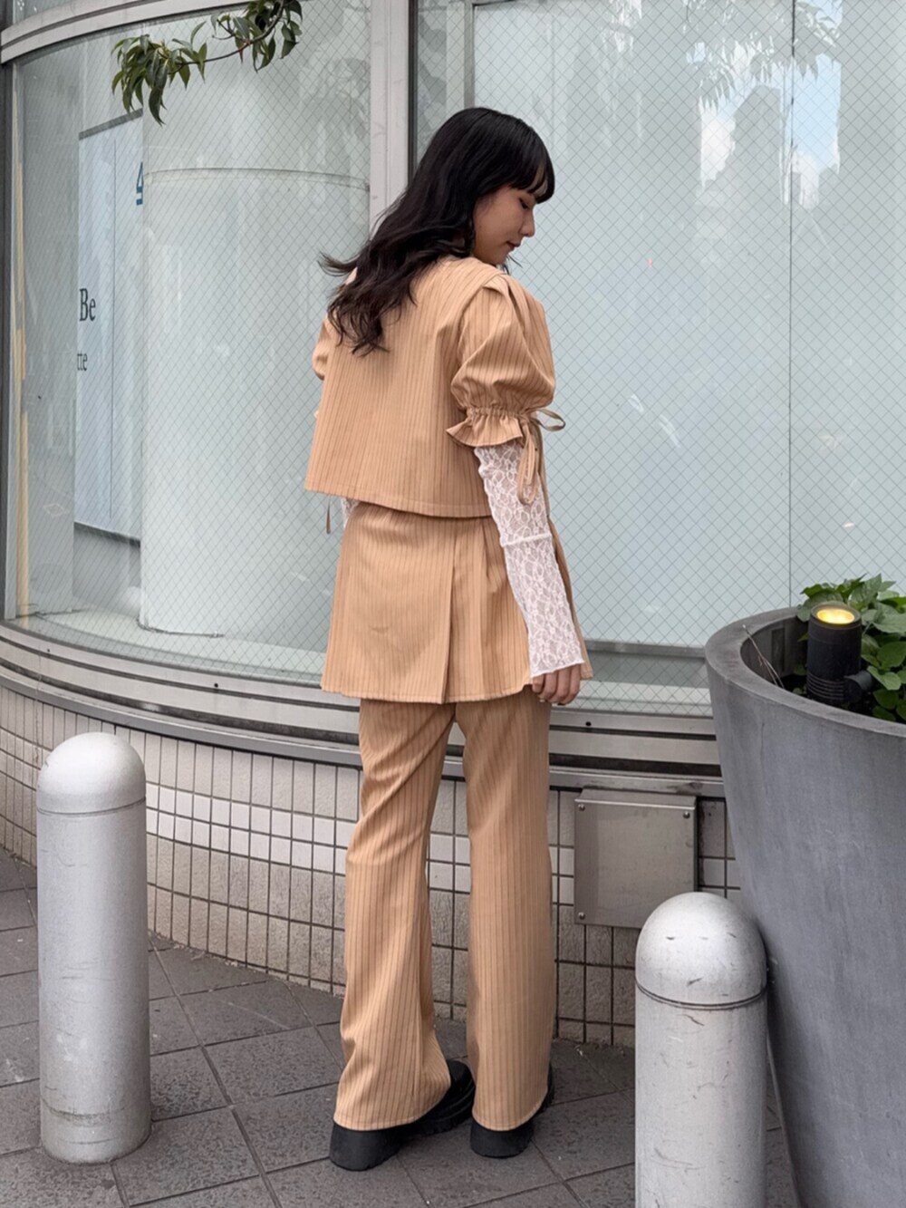 ブラック系のブーツ、ホワイト系のTシャツ/カットソー、ベージュ系のテーラードジャケットを着用したレディースの冬コーディネートの3枚目の写真