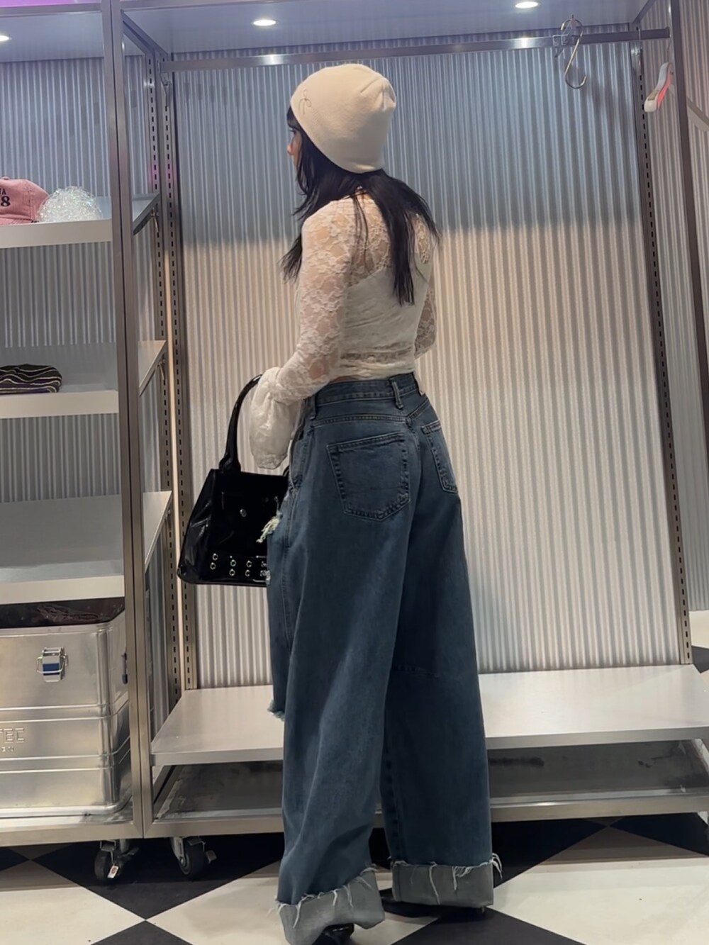 ホワイト系のTシャツ/カットソー、ブルー系のデニムパンツ、ブラック系のハンドバッグを着用したレディースの秋コーディネートの4枚目の写真