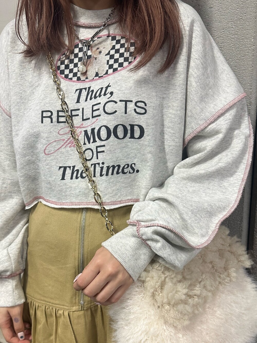 グレー系のスウェット、ホワイト系のハンドバッグ、ベージュ系のスカートを着用したレディースの冬コーディネートの6枚目の写真