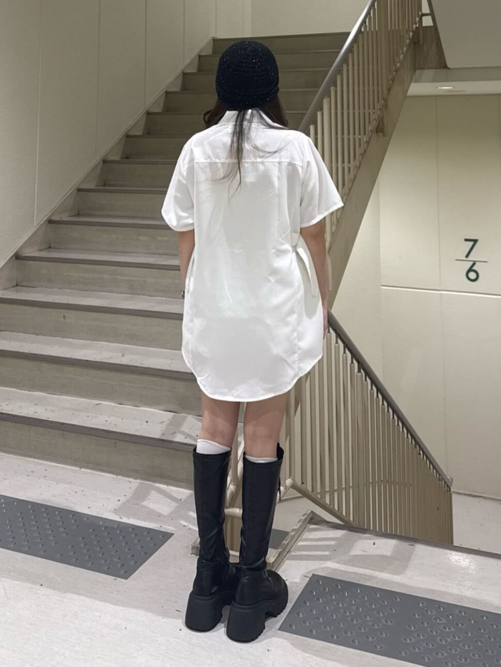 ブラック系のブーツ、ホワイト系のシャツ/ブラウス、ブラック系のニットキャップ/ビーニーを着用したレディースの春コーディネートの3枚目の写真