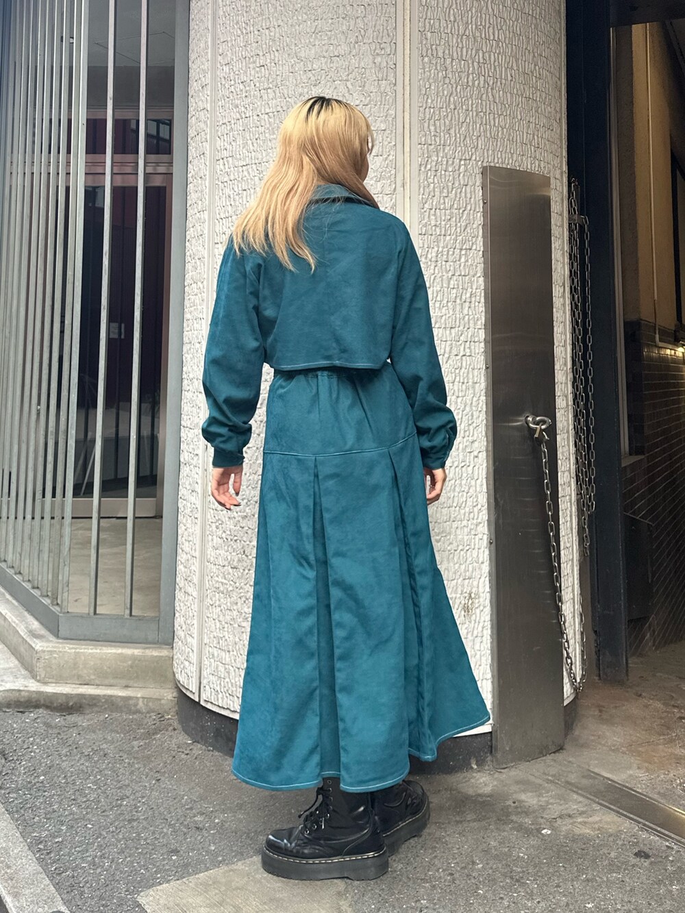 ブルー系のワンピース、ホワイト系のニット/セーター、ゴールド系のネックレスを着用したレディースの秋コーディネートの3枚目の写真