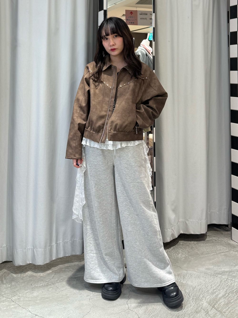 ブラック系のニット/セーター、ブラウン系のブルゾン、グレー系のスウェットパンツを着用したレディースの冬コーディネートの5枚目の写真