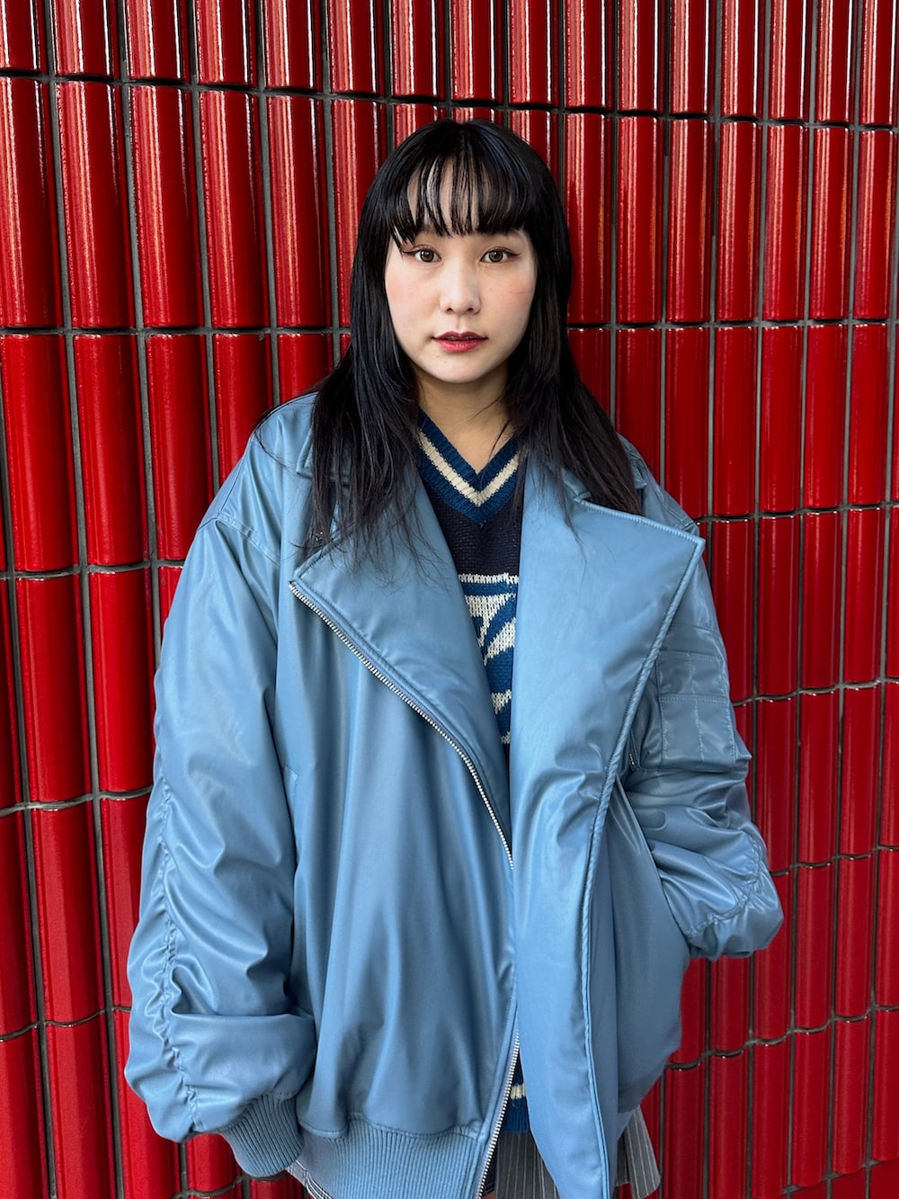 グレー系のスカート、ブラック系のブーツ、ブルー系のブルゾンを着用したレディースの秋コーディネートの5枚目の写真