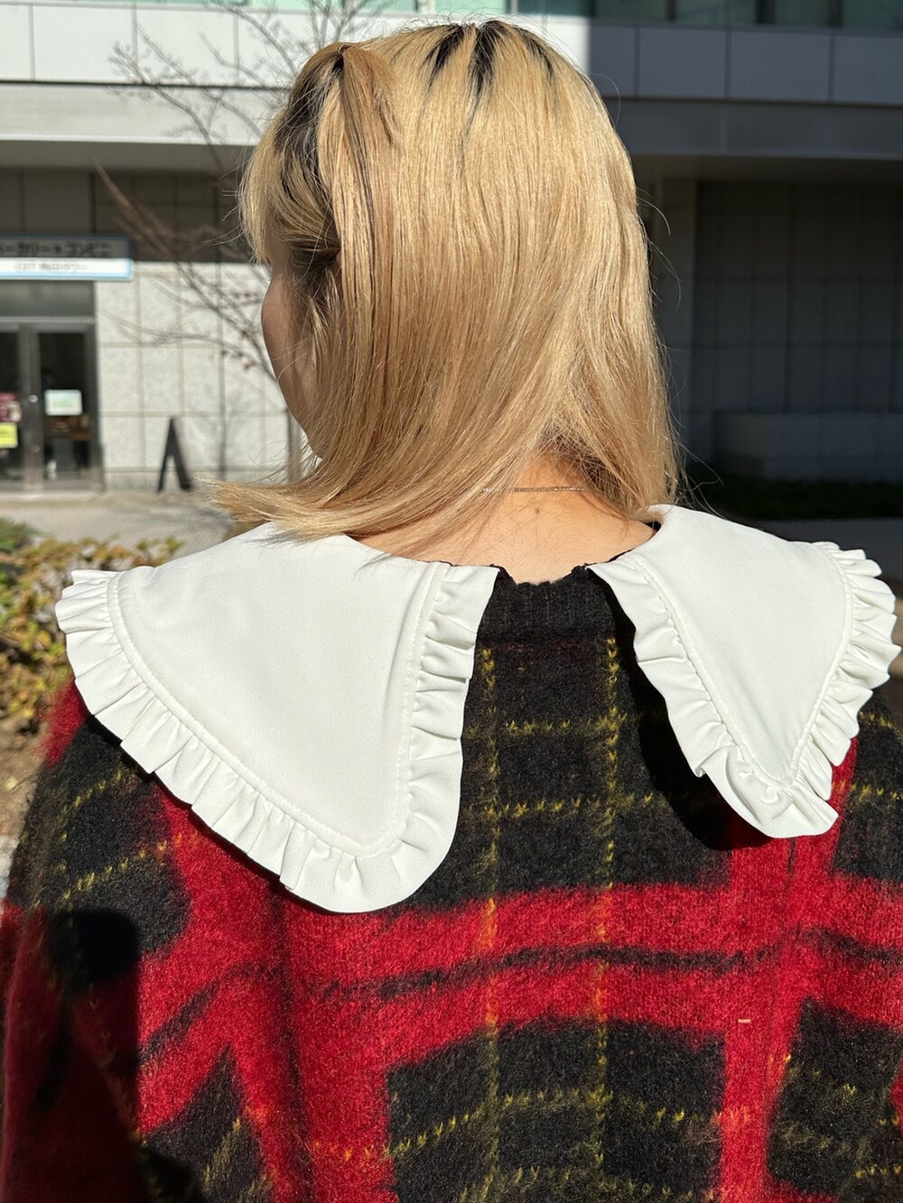 レッド系のカーディガン/ボレロ、ブラック系のワンピース、ブラック系のブーツを着用したレディースの冬コーディネートの6枚目の写真