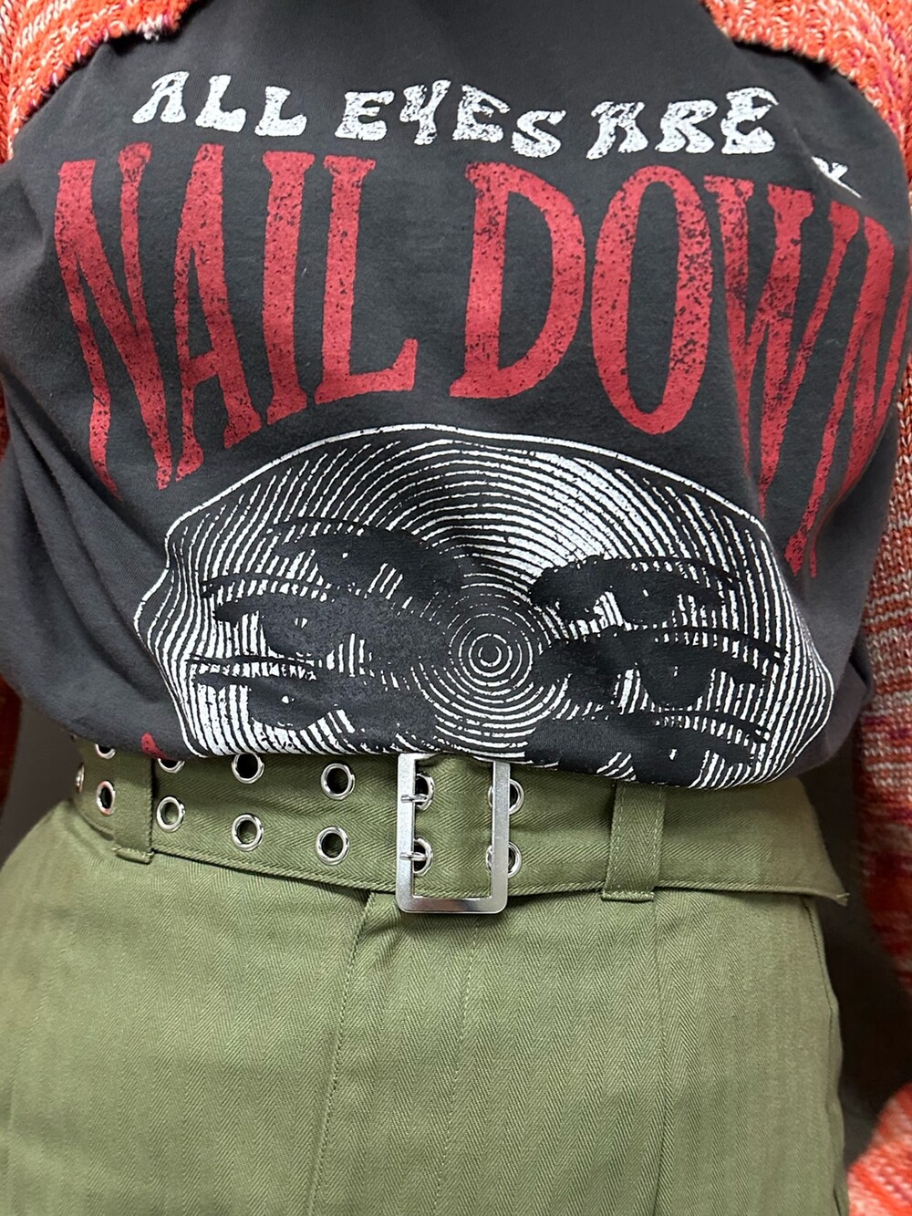 オレンジ系のニット/セーター、ブラック系のTシャツ/カットソー、ベージュ系のスカートを着用したレディースの冬コーディネートの7枚目の写真