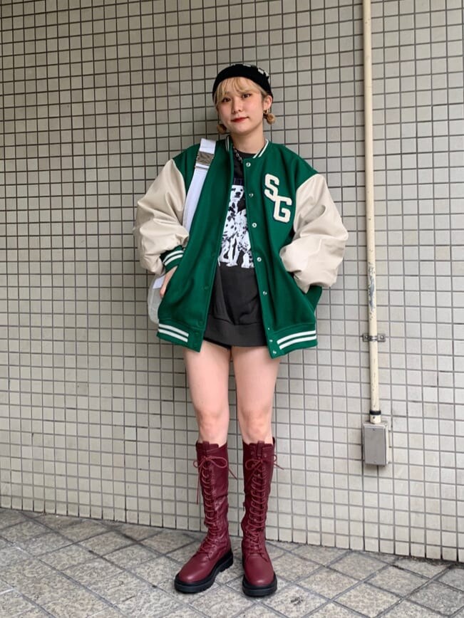 ブラック系のデニムパンツ、ブラック系のデニムパンツ、グリーン系のスタジャンを着用したレディースの秋コーディネートの2枚目の写真