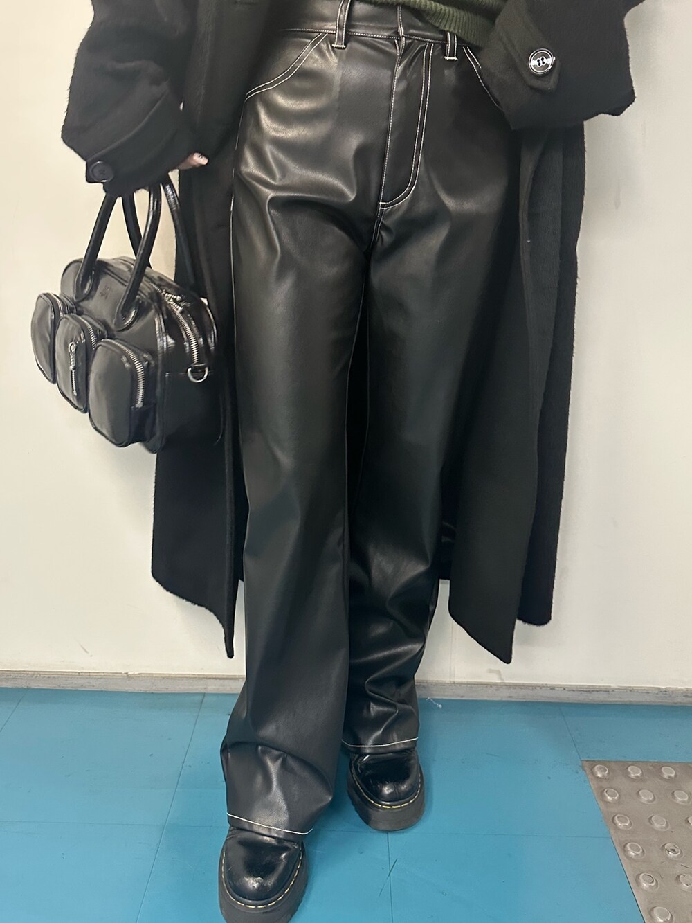 グリーン系のニット/セーター、その他のチェスターコート、ブラック系のボストンバッグを着用したレディースの冬コーディネートの4枚目の写真