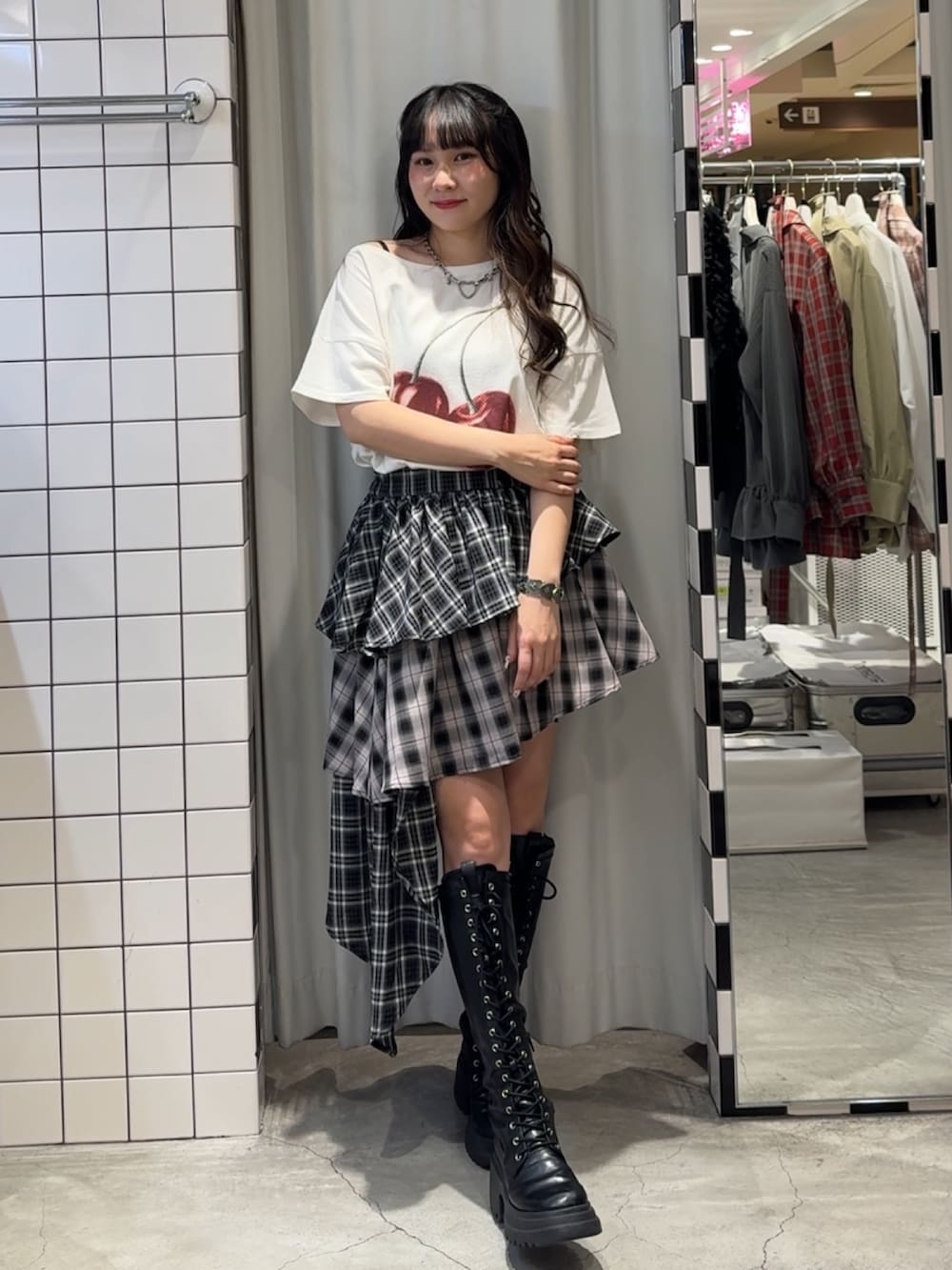 ブラック系のスカート、ブラック系のブーツ、ホワイト系のTシャツ/カットソーを着用したレディースの春コーディネートの5枚目の写真