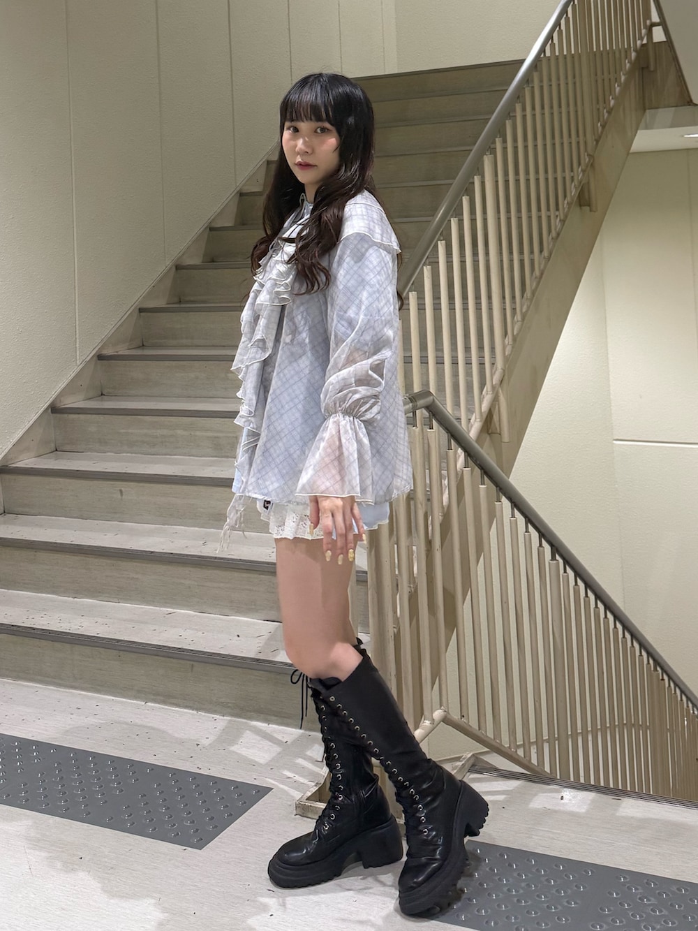 グレー系のシャツ/ブラウス、ホワイト系のスカート、ブラック系のブーツを着用したレディースの春コーディネートの2枚目の写真