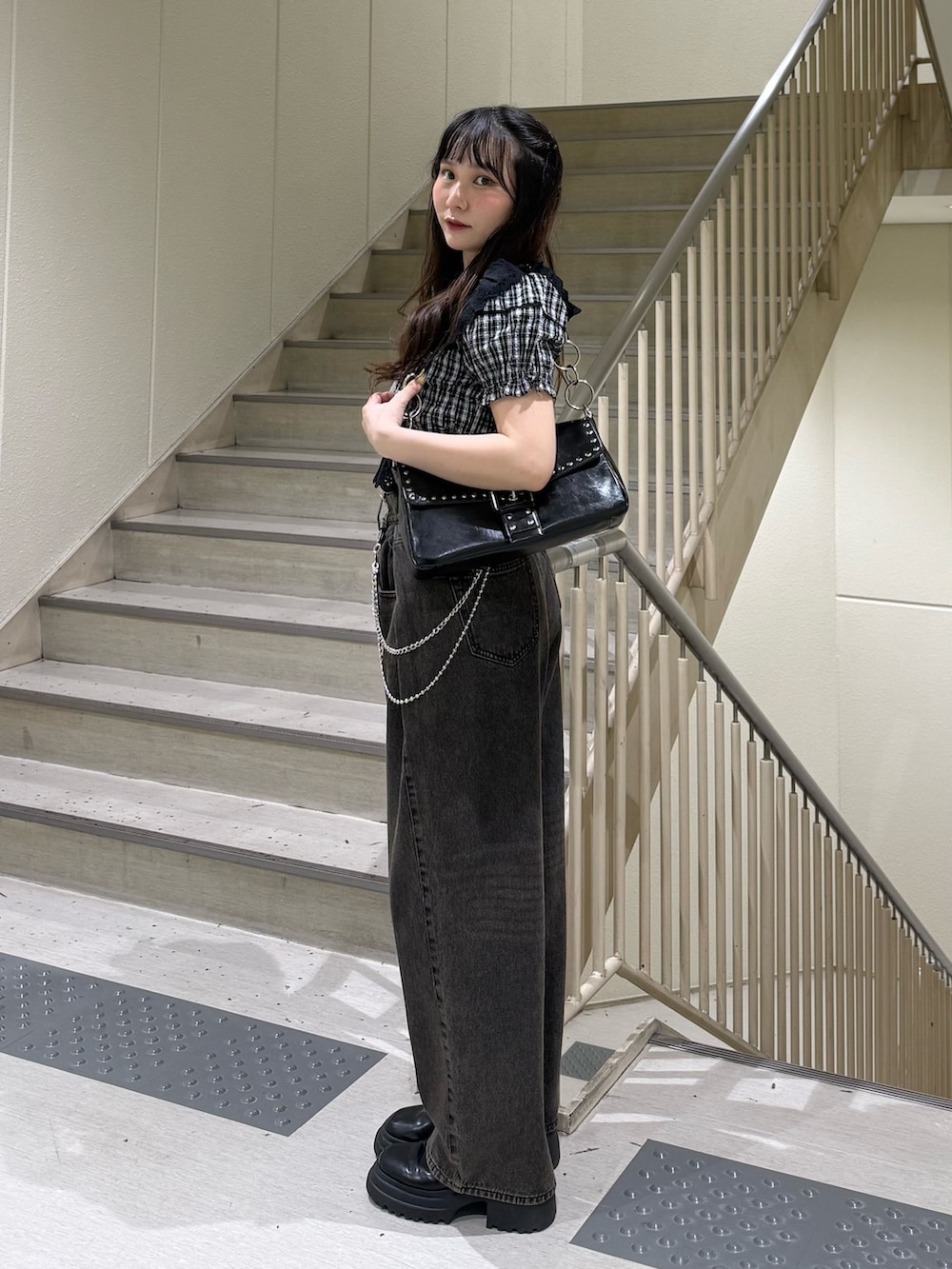 ブラック系のシャツ/ブラウス、ブラック系のデニムパンツ、ブラック系のハンドバッグを着用したレディースの春コーディネートの2枚目の写真