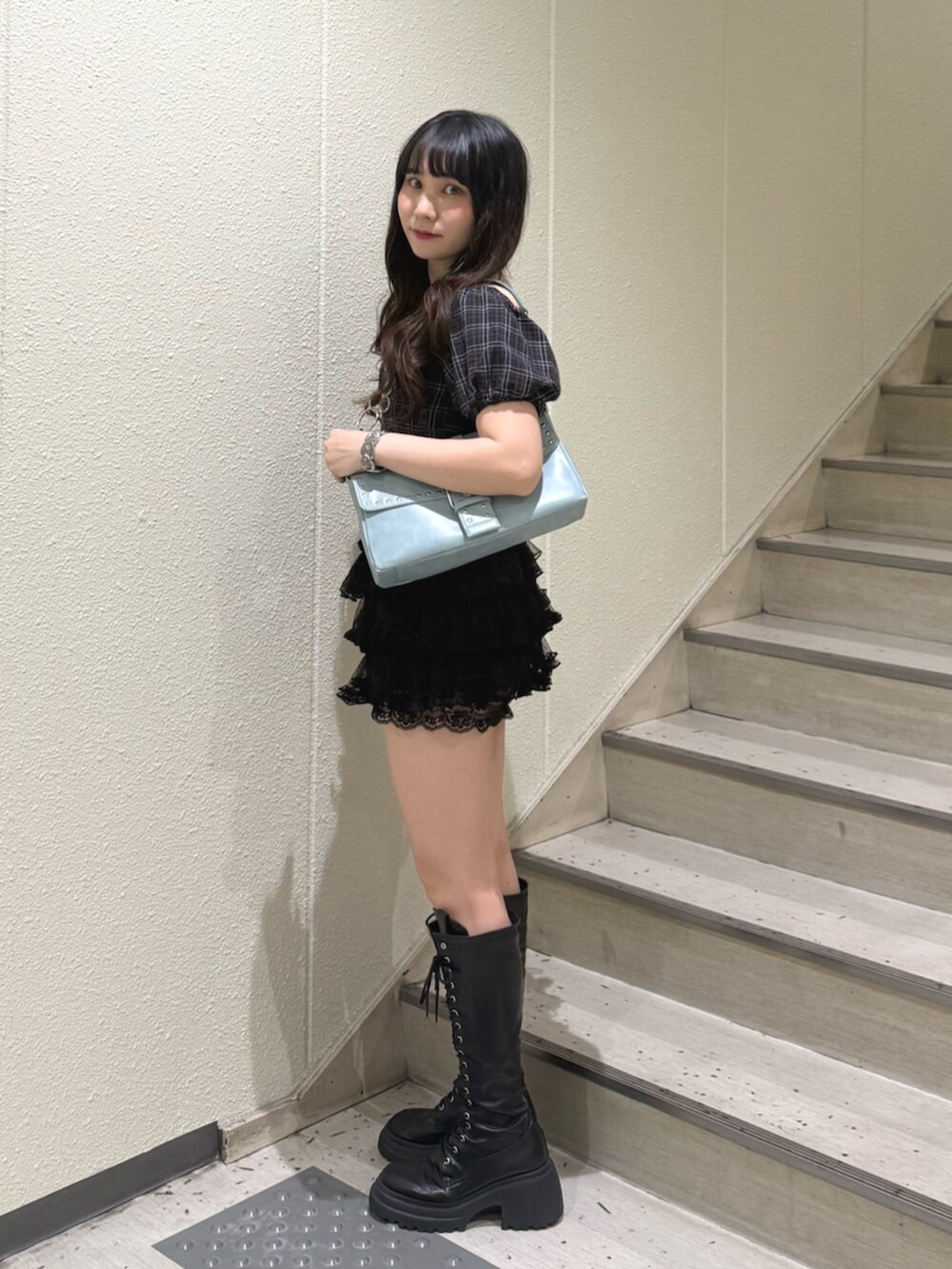 ブルー系のハンドバッグ、ブラック系のブーツ、ブラック系のその他パンツを着用したレディースの夏コーディネートの2枚目の写真