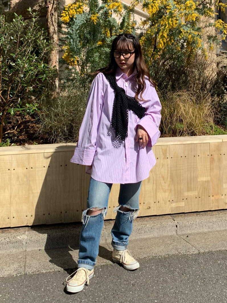 ピンク系のシャツ/ブラウス、ブラック系のTシャツ/カットソー、ブルー系のデニムパンツを着用したレディースの春コーディネートの2枚目の写真