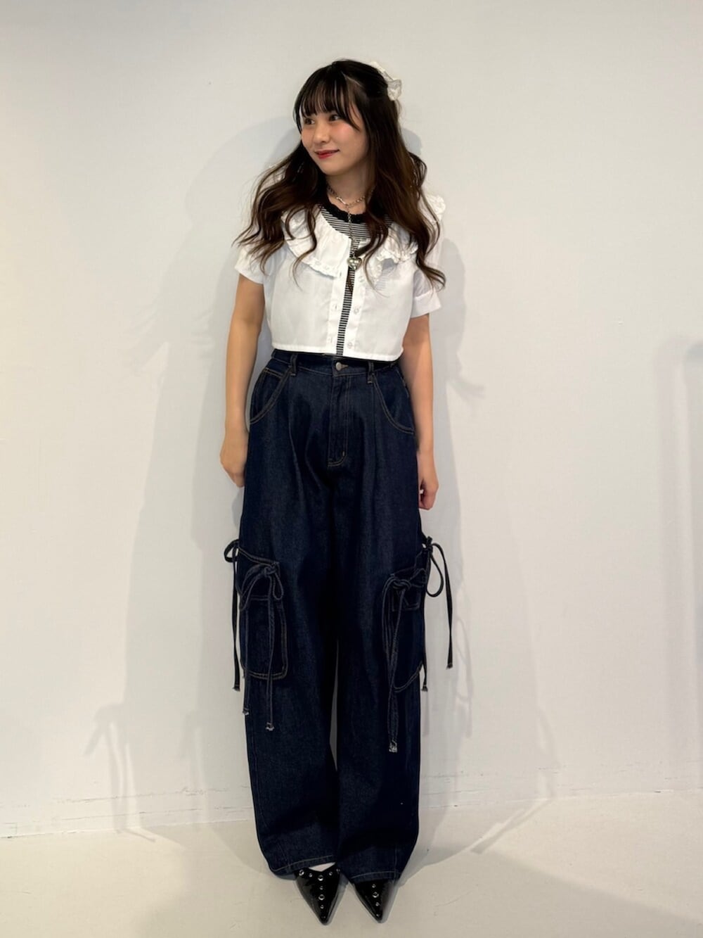 ブラック系のパンプス、ホワイト系のシャツ/ブラウス、ブルー系のデニムパンツを着用したレディースの春コーディネートの5枚目の写真