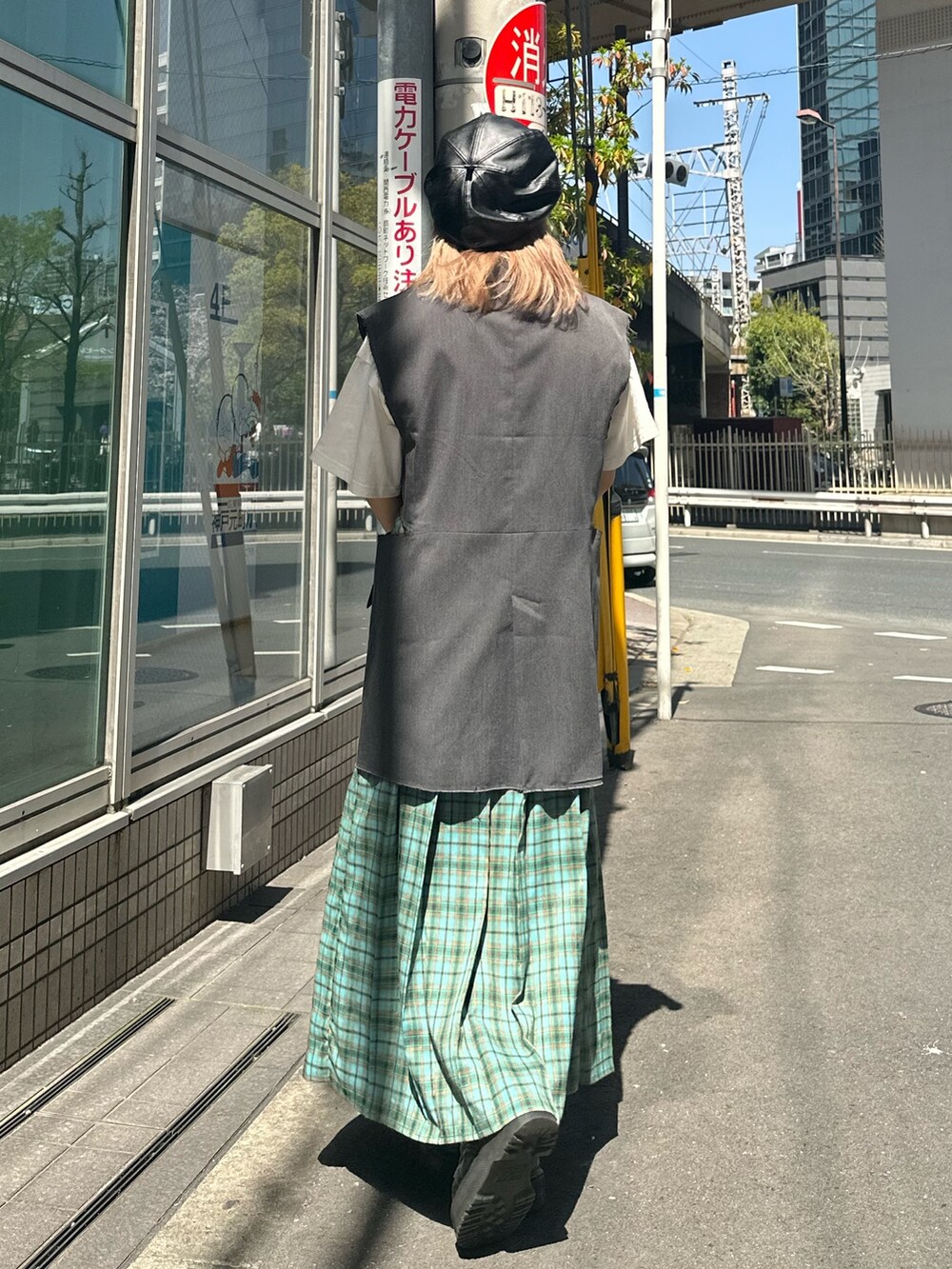 グリーン系のスカート、グレー系のベスト、ホワイト系のTシャツ/カットソーを着用したレディースの春コーディネートの3枚目の写真