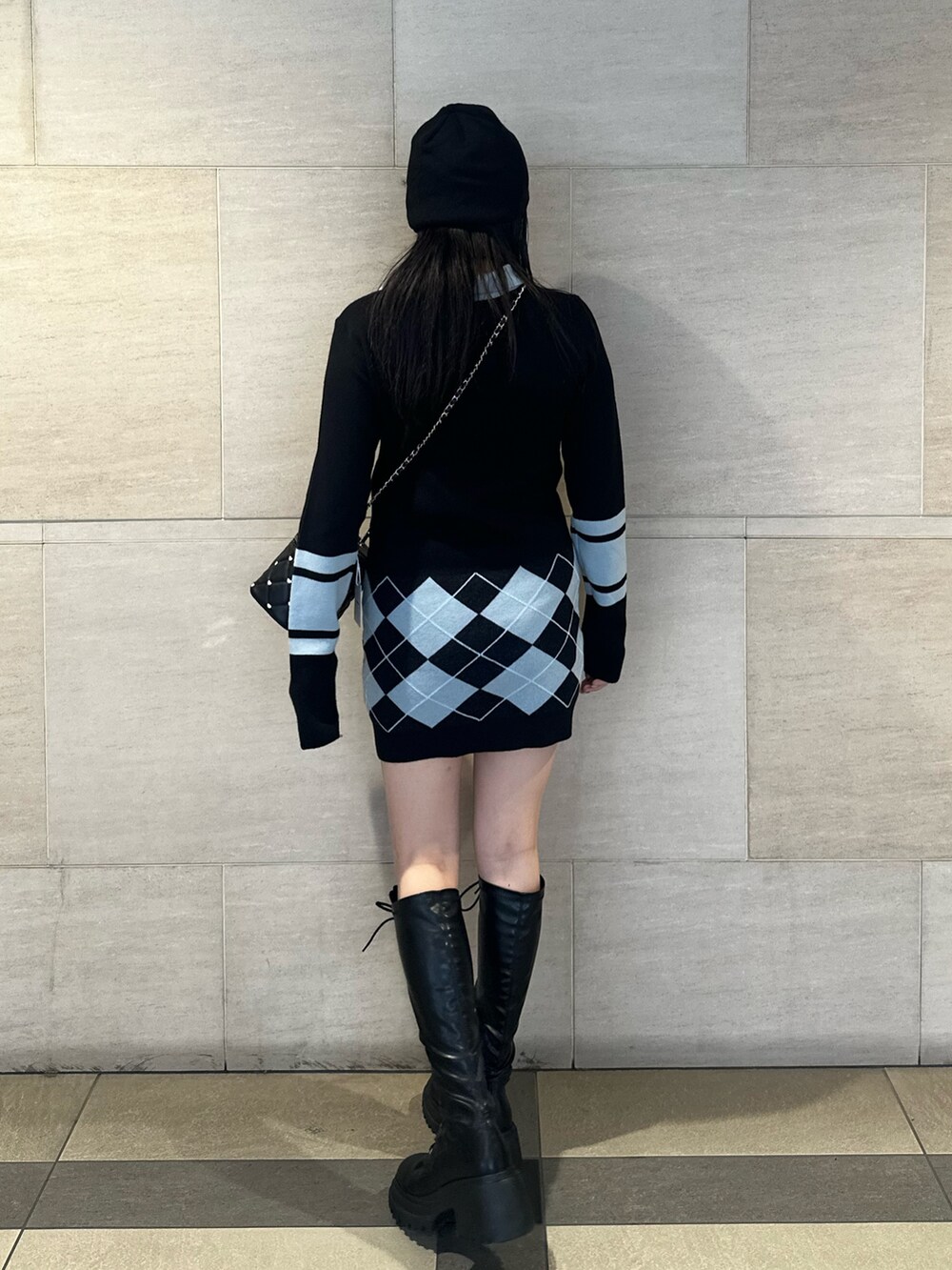 ブラック系のブーツ、ブラック系のワンピース、ブラック系のショルダーバッグを着用したレディースの秋コーディネートの3枚目の写真