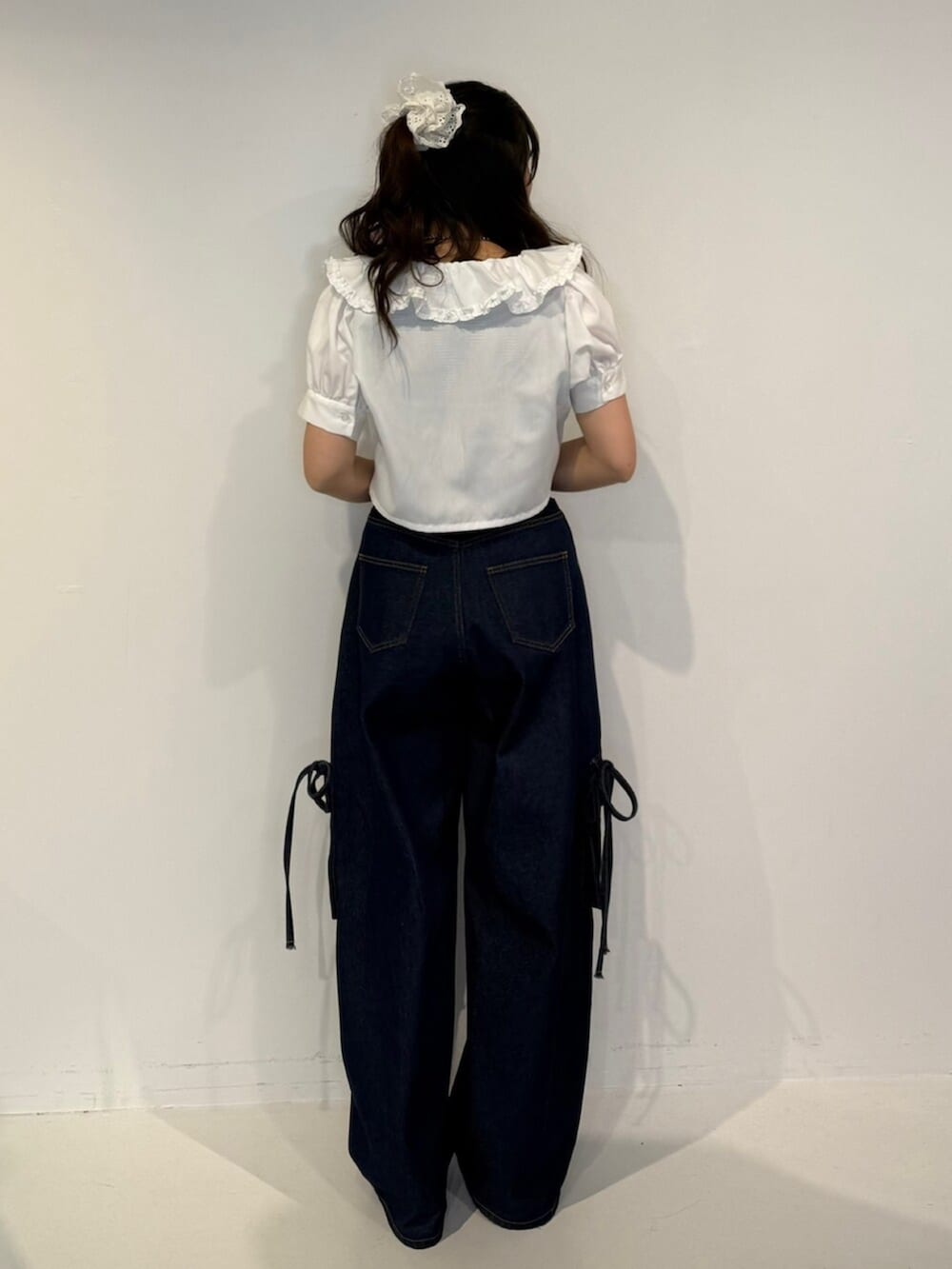 ブラック系のパンプス、ホワイト系のシャツ/ブラウス、ブルー系のデニムパンツを着用したレディースの春コーディネートの4枚目の写真
