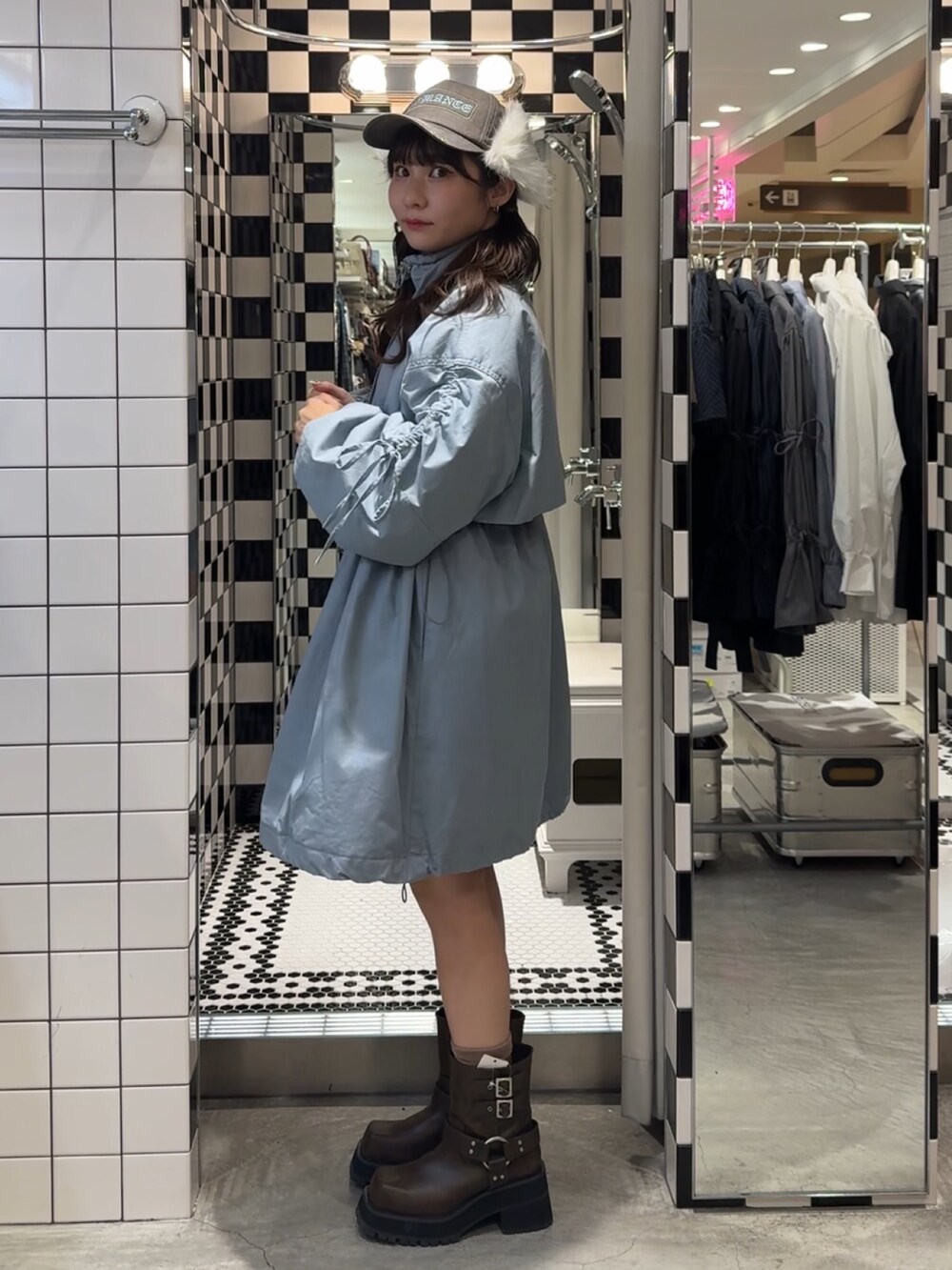 ブルー系のモッズコート、ブラウン系のブーツ、ブラウン系のキャップを着用したレディースの冬コーディネートの3枚目の写真