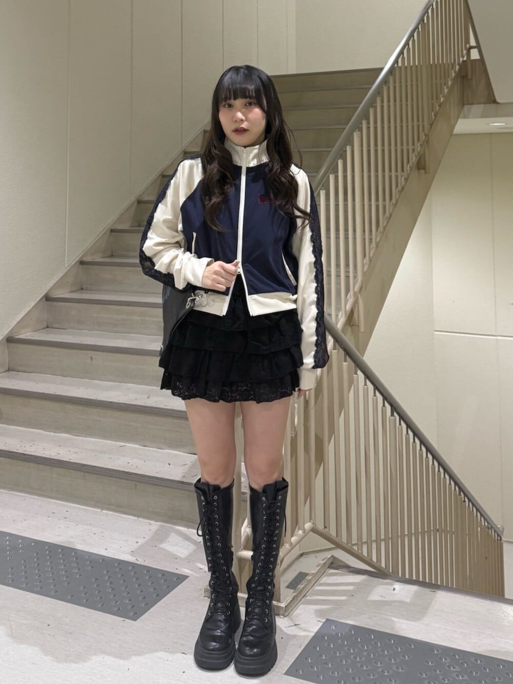 ブラック系のブーツ、ブルー系のジャージ、ブラック系のスカートを着用したレディースの春コーディネートの6枚目の写真