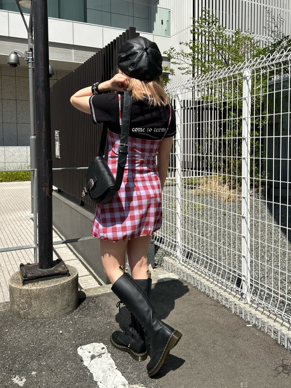 ブラック系のショルダーバッグ、ブラック系のブーツ、ブラック系のTシャツ/カットソーを着用したレディースの春コーディネートの2枚目の写真