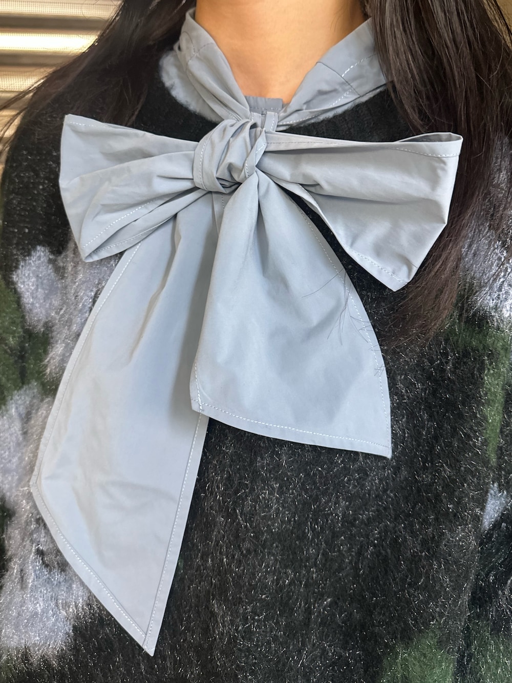 グレー系のスカート、ブラック系のニット/セーター、ブルー系のシャツ/ブラウスを着用したレディースの秋コーディネートの6枚目の写真