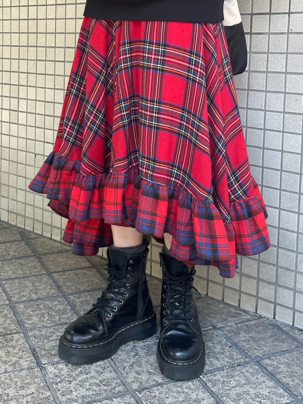 レッド系のスカート、ブラック系のパーカー、ブラック系のハンドバッグを着用したレディースの秋コーディネートの8枚目の写真