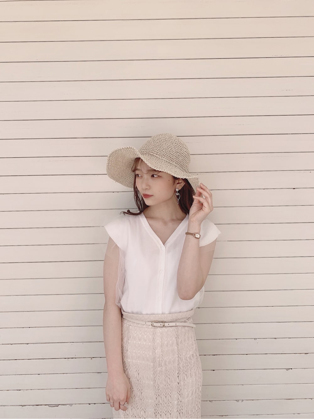 ホワイト系のスカート、ブラウン系のパンプス、ホワイト系のニット/セーターを着用したレディースの春コーディネートの4枚目の写真