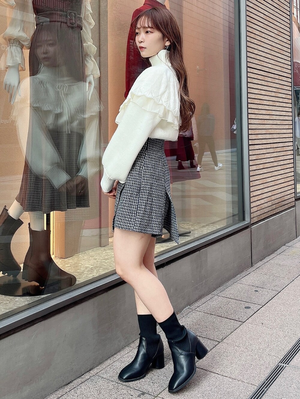 ホワイト系のニット/セーター、ブルー系のスカート、ブラック系のブーツを着用したレディースの秋コーディネートの3枚目の写真