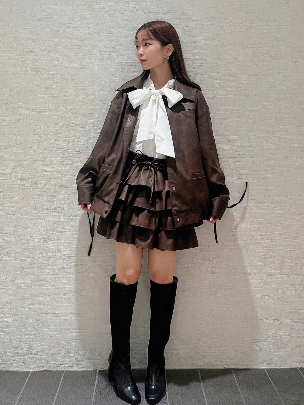 ブラック系のブーツ、ホワイト系のシャツ/ブラウス、ブラウン系のブルゾンを着用したレディースの秋コーディネートの3枚目の写真