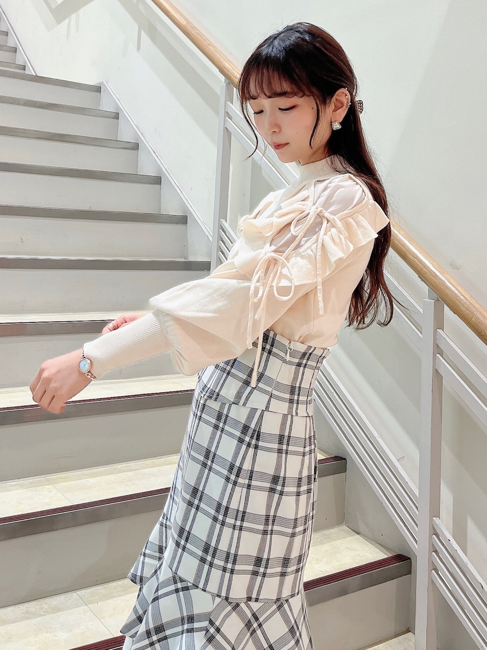 ホワイト系のニット/セーター、ホワイト系のスカート、ベージュ系のブーツを着用したレディースの冬コーディネートの6枚目の写真