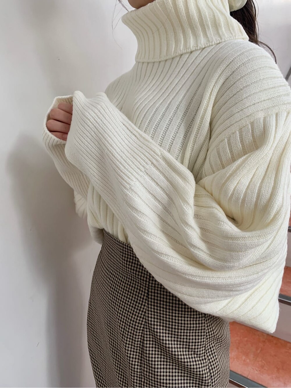 ブラウン系のブーツ、ブラウン系のスカート、ホワイト系のニット/セーターを着用したレディースの秋コーディネートの9枚目の写真