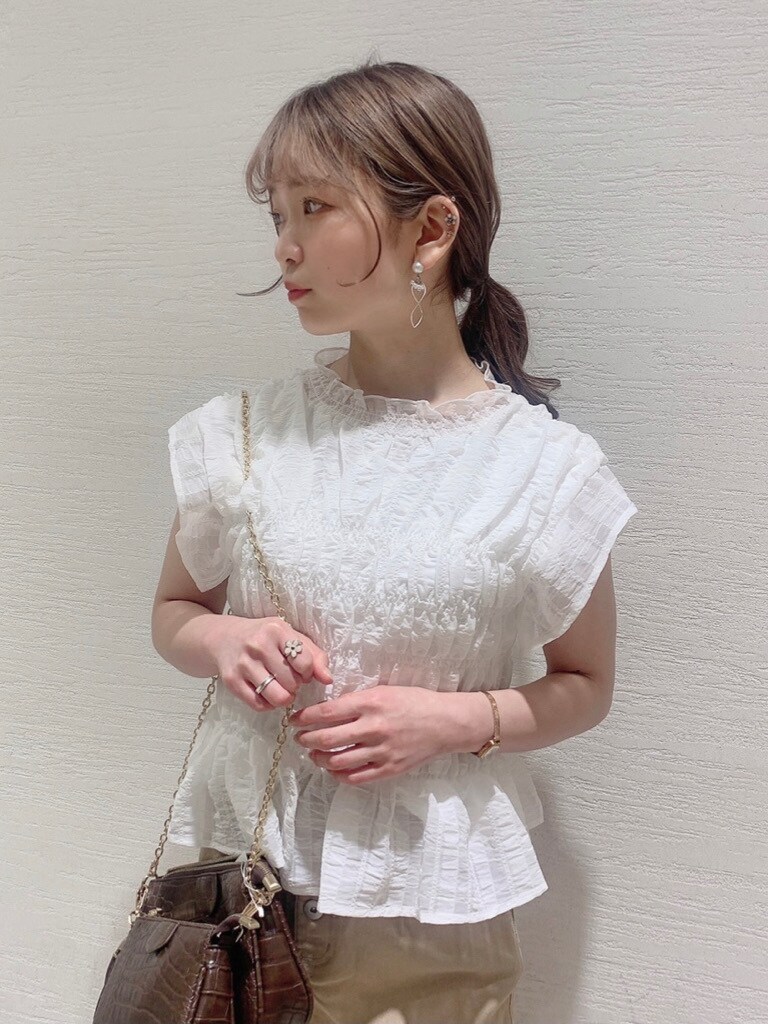 ホワイト系のシャツ/ブラウス、ベージュ系のスカート、ブラウン系のサンダルを着用したレディースの春コーディネートの4枚目の写真