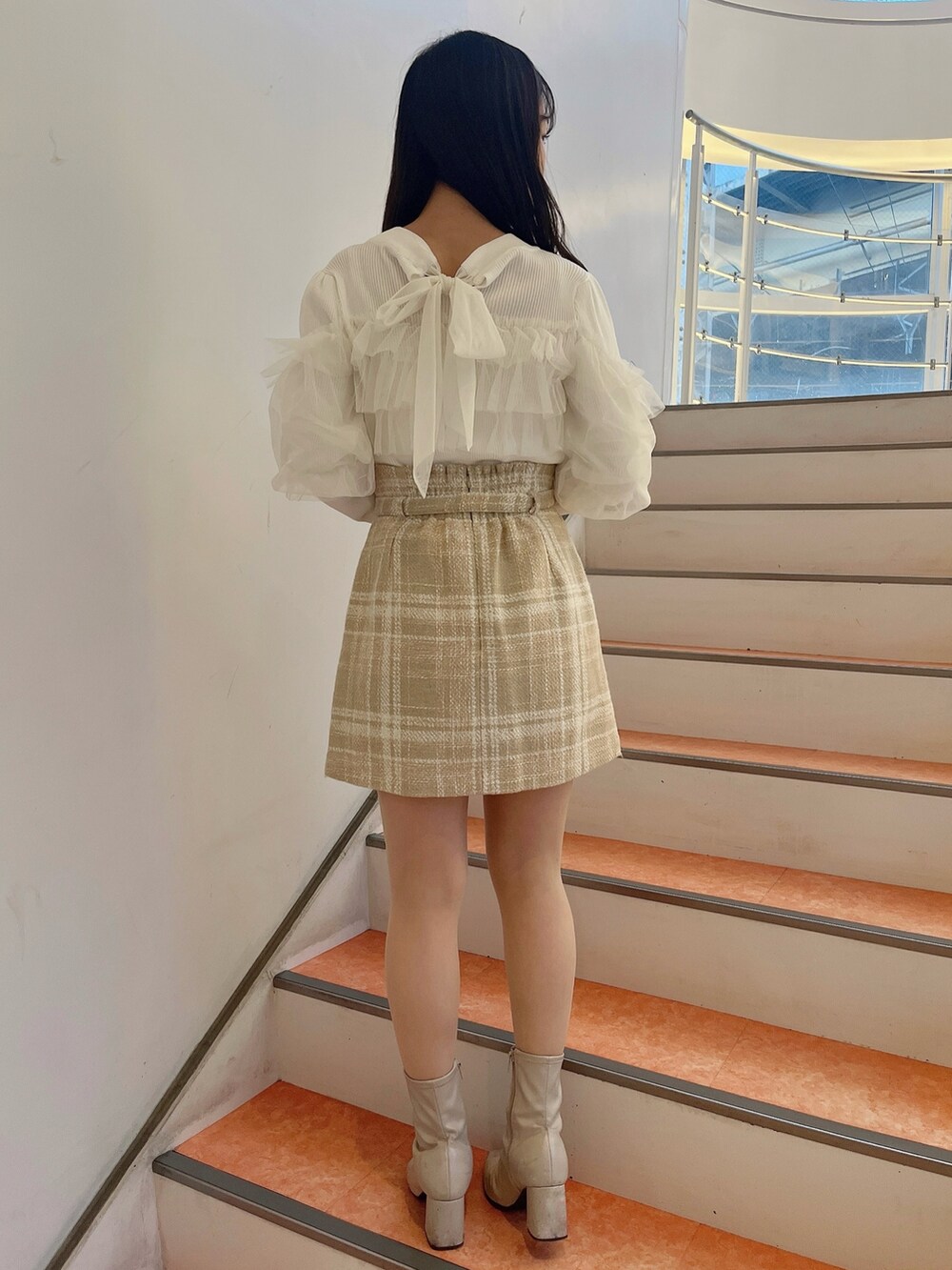 ホワイト系のニット/セーター、ベージュ系のスカート、ベージュ系のブーツを着用したレディースの冬コーディネートの5枚目の写真