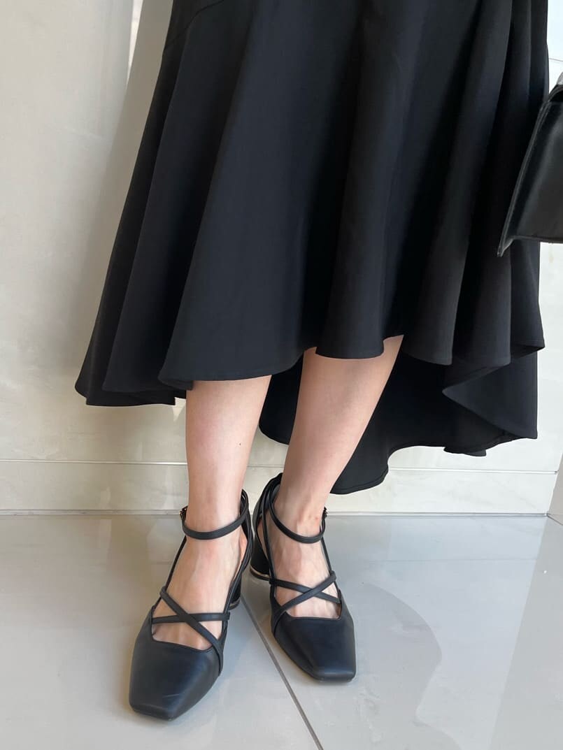 グレー系のニット/セーター、ブラック系のスカート、ブラック系のパンプスを着用したレディースの夏コーディネートの10枚目の写真