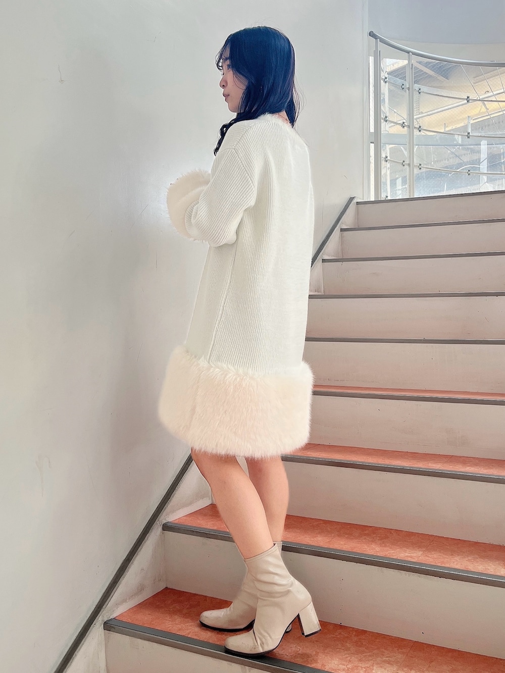 ベージュ系のブーツ、ホワイト系のワンピースを着用したレディースの冬コーディネートの3枚目の写真