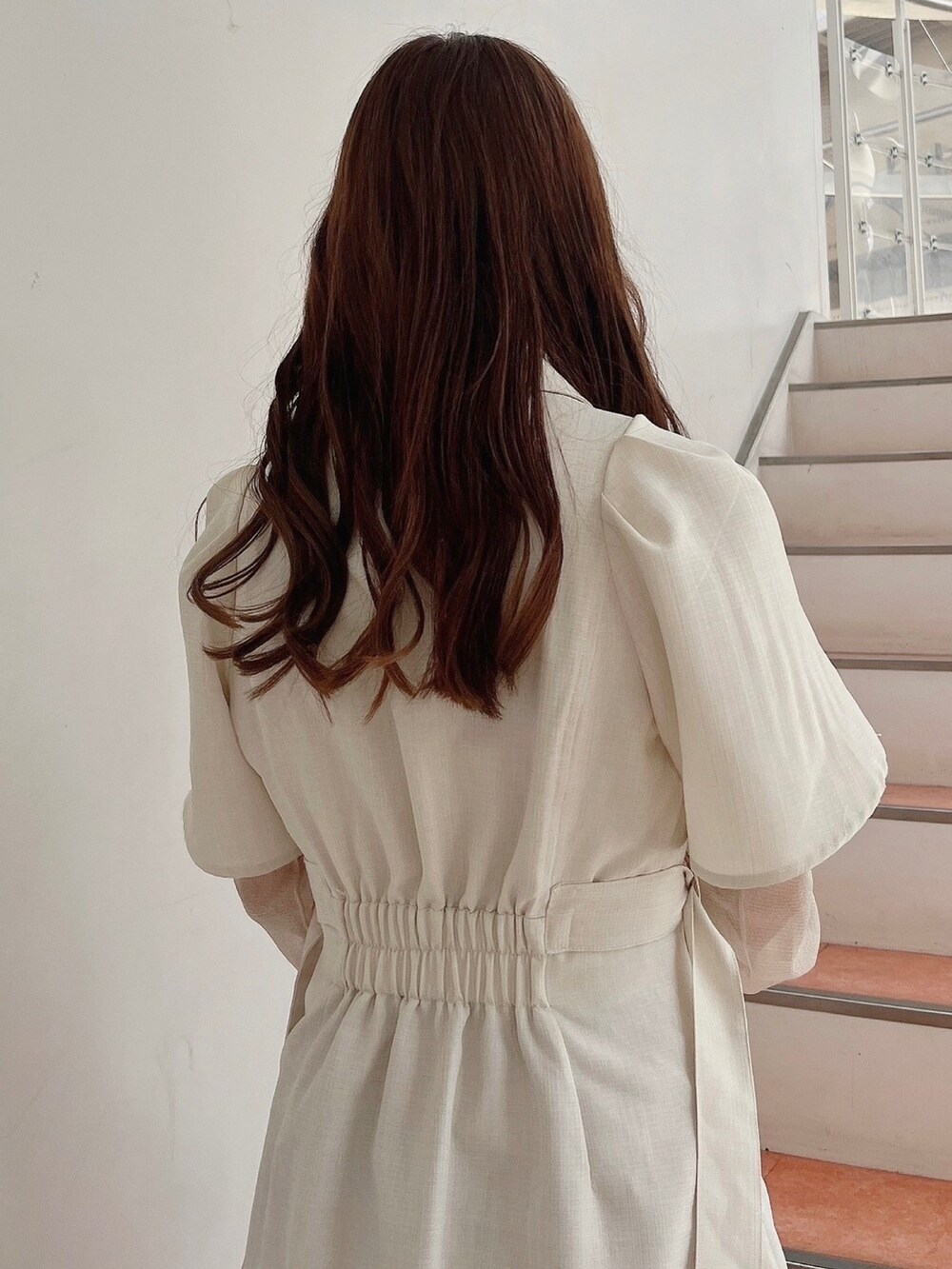 ホワイト系のワンピース、ベージュ系のブーツを着用したレディースの春コーディネートの7枚目の写真