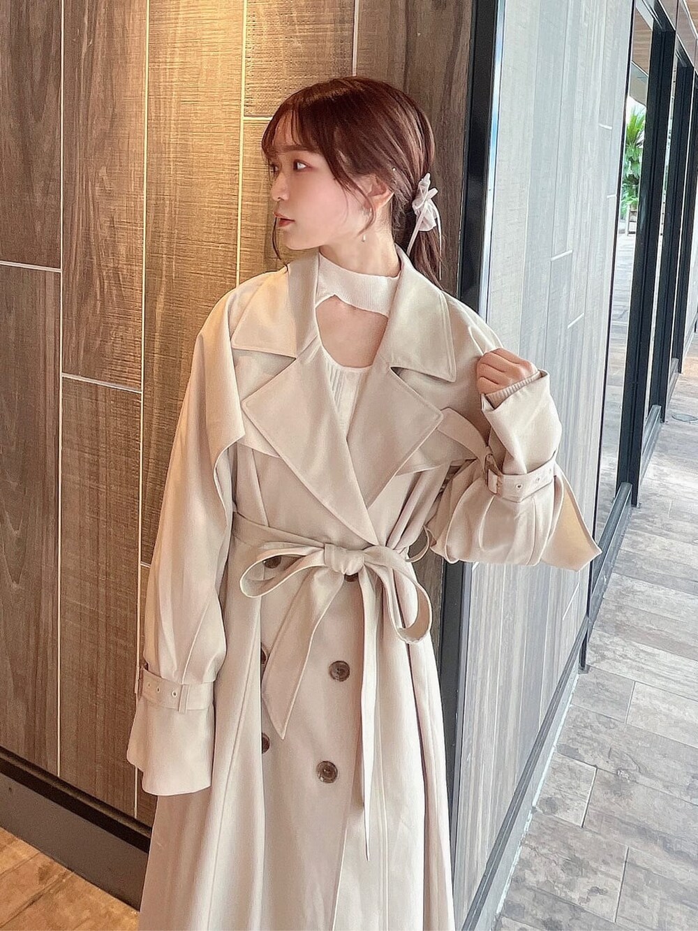 ベージュ系のトレンチコート、ベージュ系のブーツ、ベージュ系のスカートを着用したレディースの秋コーディネートの5枚目の写真