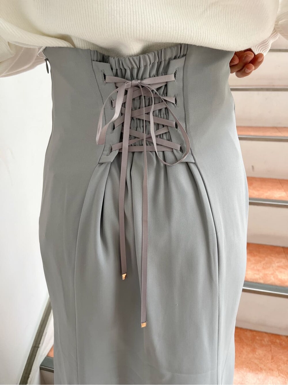 ベージュ系のブーツ、グレー系のスカート、ホワイト系のニット/セーターを着用したレディースの秋コーディネートの10枚目の写真