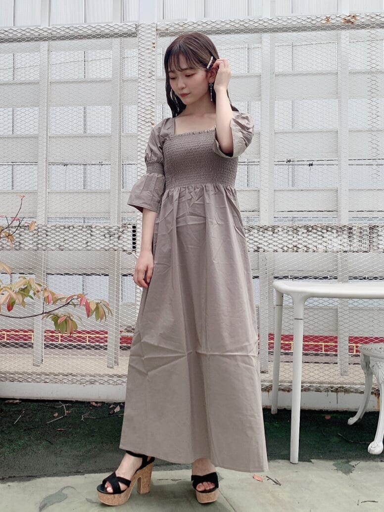 ブラック系のサンダル、ベージュ系のワンピースを着用したレディースの夏コーディネートの2枚目の写真