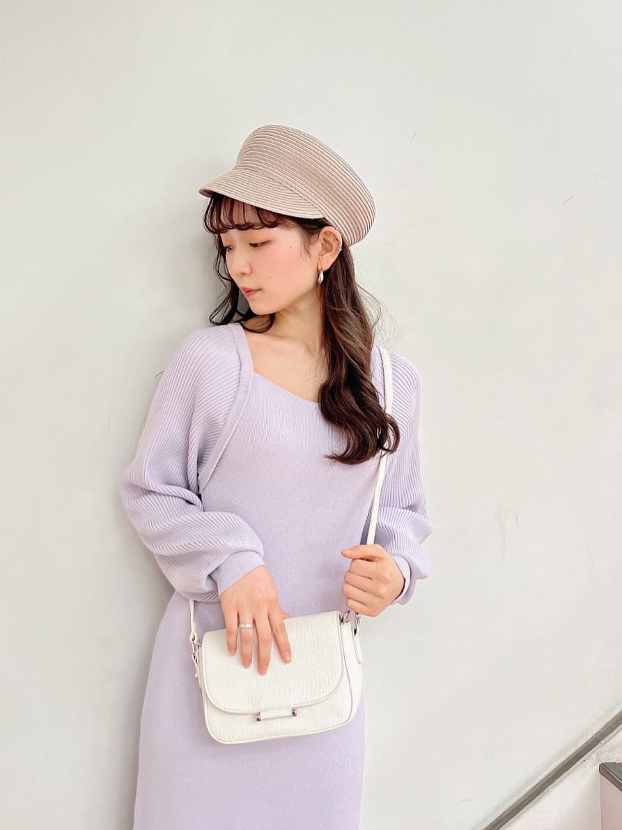 パープル系のワンピース、ブラック系のブーツ、ホワイト系のショルダーバッグを着用したレディースの冬コーディネートの6枚目の写真