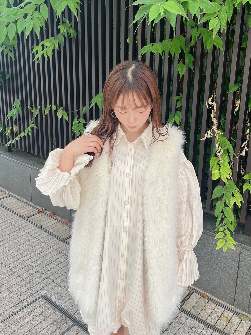 ホワイト系のベスト、ベージュ系のワンピース、ホワイト系のブーツを着用したレディースの秋コーディネートの8枚目の写真