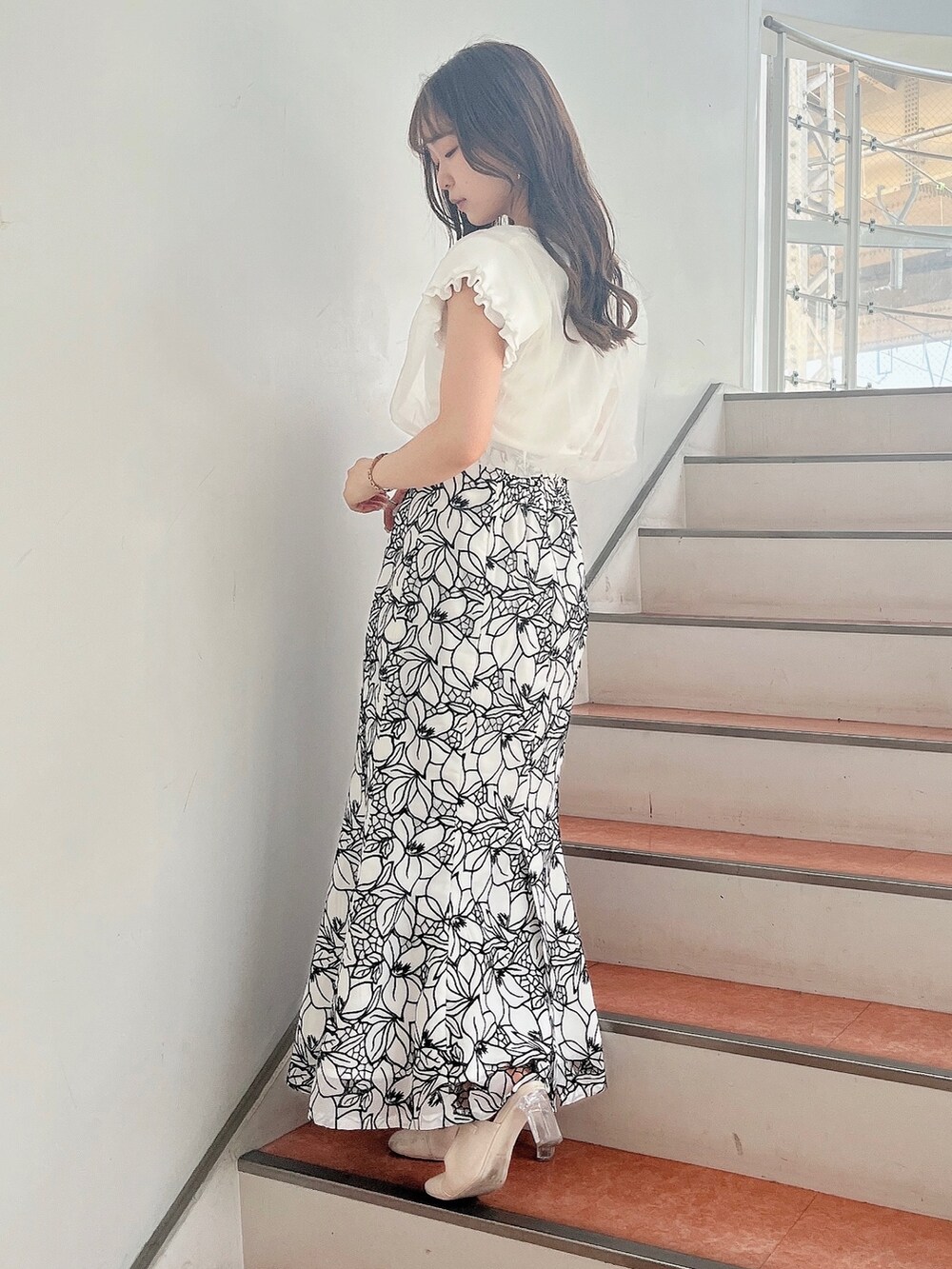 ホワイト系のパンプス、ホワイト系のスカート、ホワイト系のニット/セーターを着用したレディースの春コーディネートの3枚目の写真