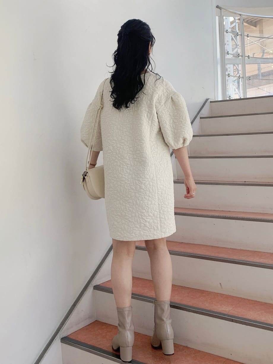 ホワイト系のチュニック、ベージュ系のショルダーバッグ、ベージュ系のブーツを着用したレディースの秋コーディネートの4枚目の写真