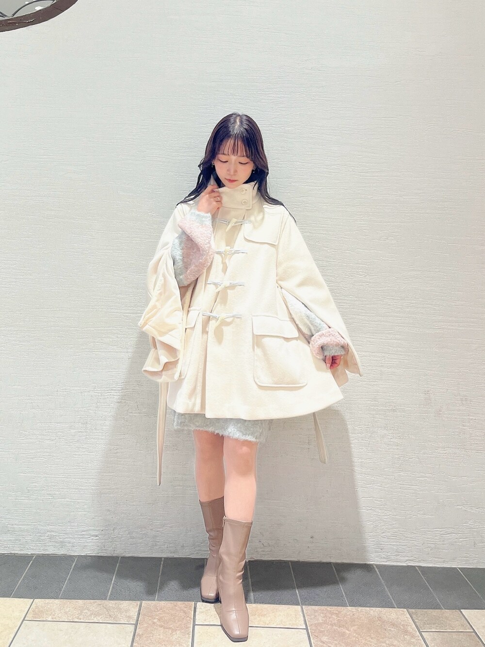 ベージュ系のブーツ、ホワイト系のダッフルコート、ピンク系のニット/セーターを着用したレディースの秋コーディネートの2枚目の写真