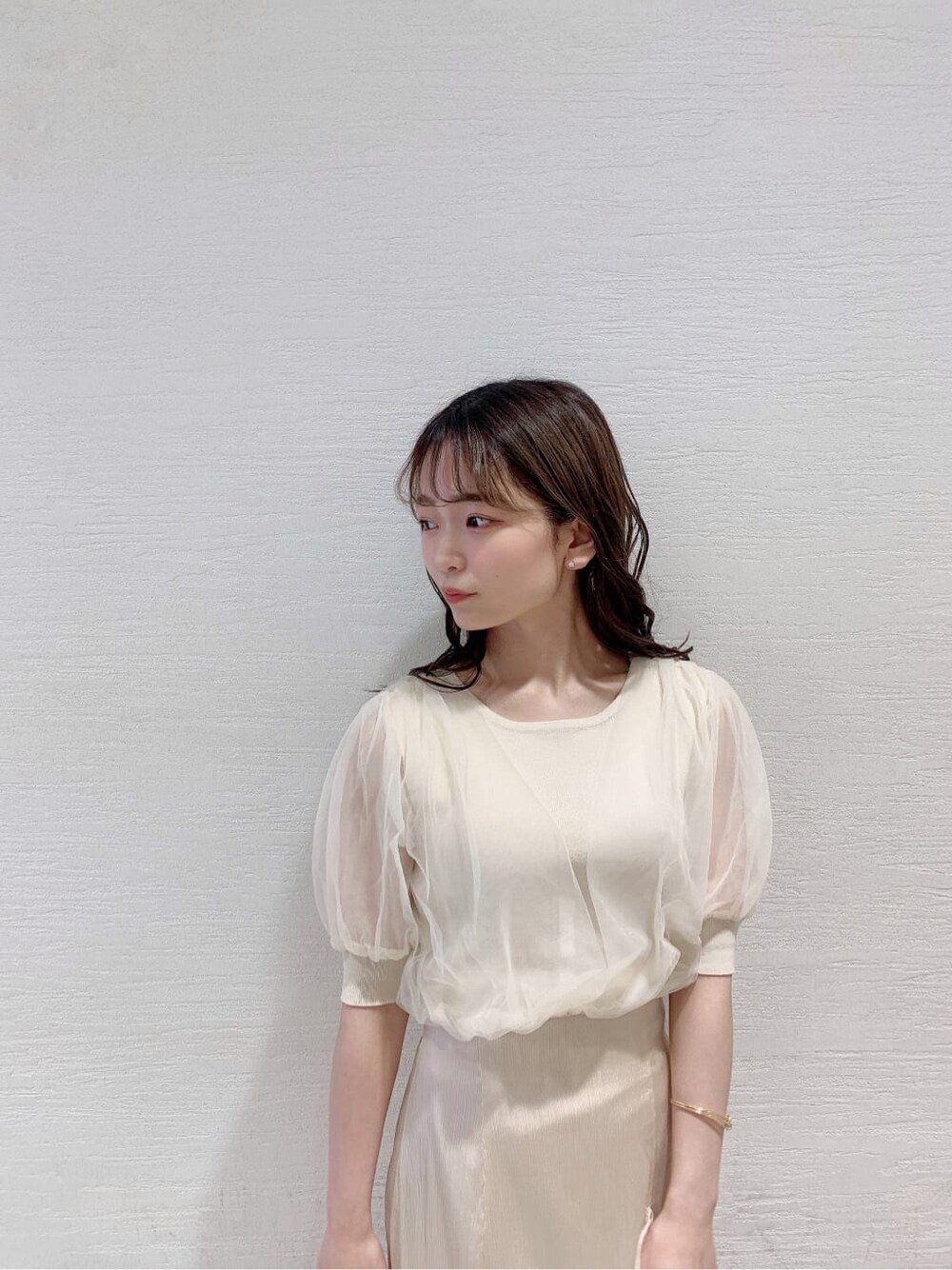 ホワイト系のスカート、ホワイト系のニット/セーター、オレンジ系のサンダルを着用したレディースの夏コーディネートの6枚目の写真